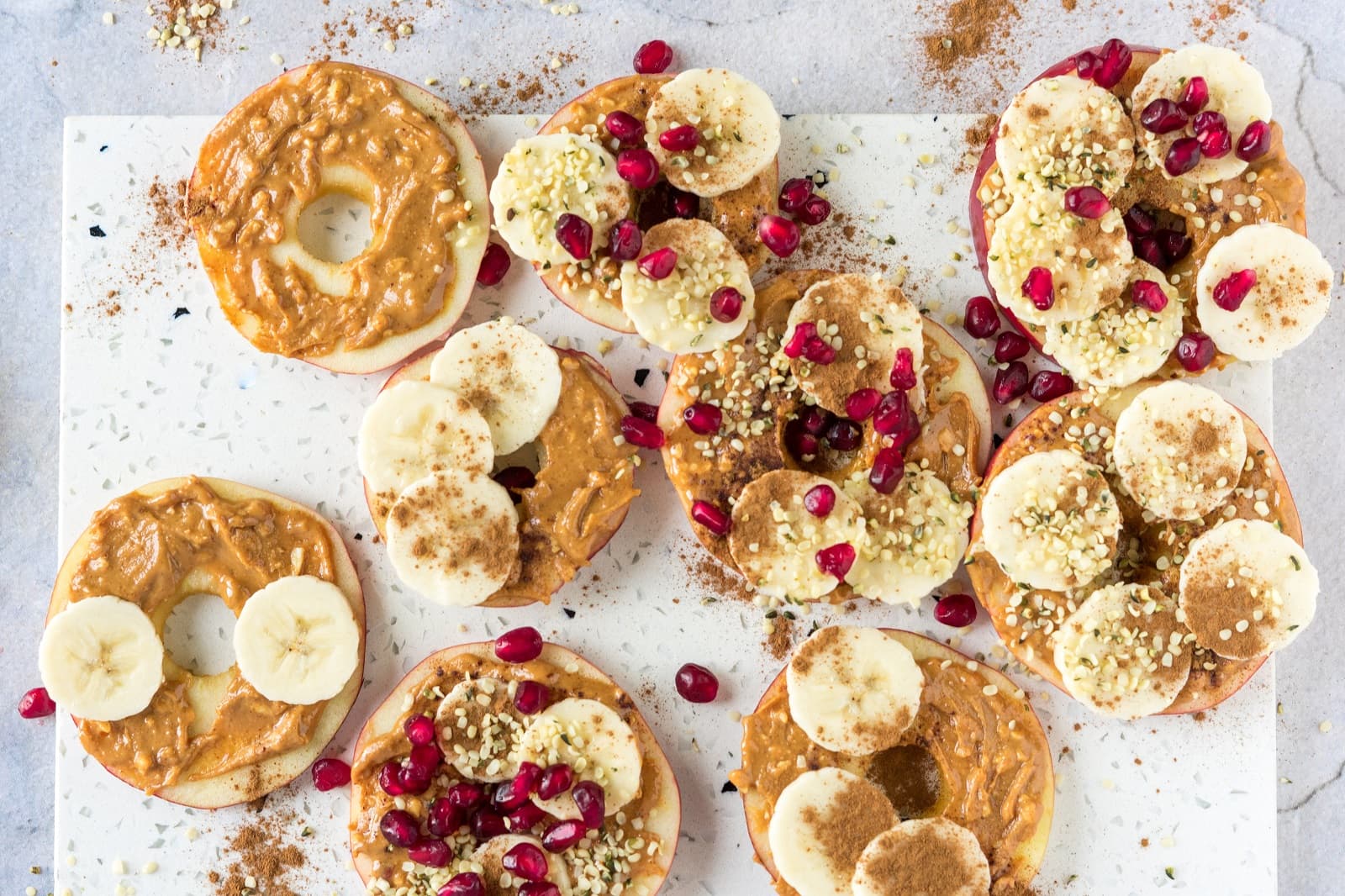 Apple slices with nut butter, banana, cinnamon and hemp seeds