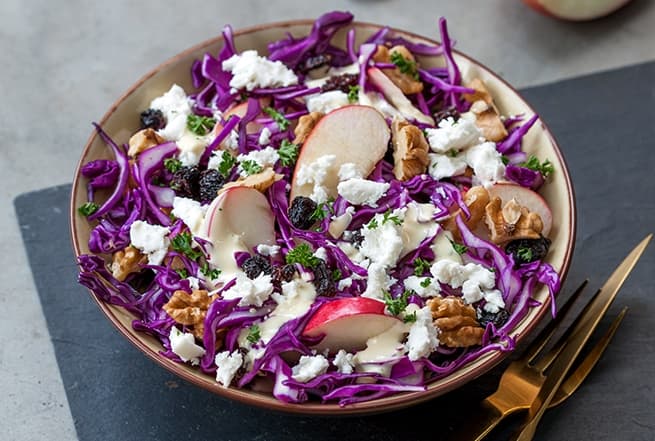 Purple pointed cabbage salad with apple, nuts and goat cheese